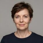 Профессиональный портрет уверенного российского бизнесмена с дружелюбным взглядом на размытом нейтральном фоне